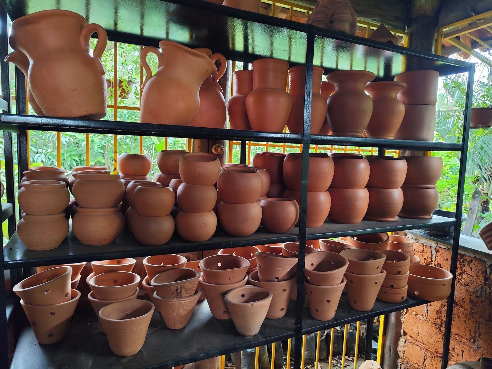 Prateleiras com vasos e moringas de barro